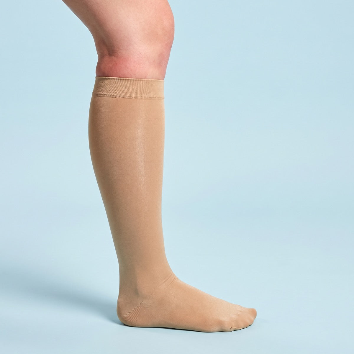 Een lange compressiekous die net onder de knie in de huid drukt