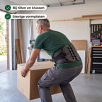 Man tilt een verhuisdoos in de garage met de rugbrace om