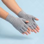 Grijze vingerloze compressiehandschoenen op lichtblauwe achtergrond, vingertoppen en duimtop open