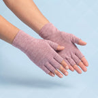Roze vingerloze compressiehandschoenen op lichtblauwe achtergrond, vingertoppen en duimtop open