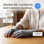 Vrouw met grijze compressiehandschoenen legt haar handen op tafel, met drie punten over de lichte druk en de vrije vingertoppen