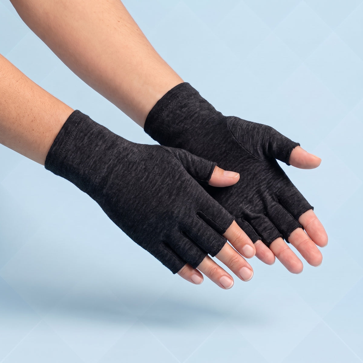Zwarte vingerloze compressiehandschoenen op lichtblauwe achtergrond, vingertoppen en duimtop open