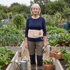 Vrouw van rond de 60 staat in haar moestuin met de beige decompressiegordel om