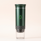 De espressomachine in metallic groen op een crèmekleurige achtergrond