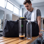 De espressomachine op een kleedkamerbankje naast een flesje water van een halve liter en een sporttas