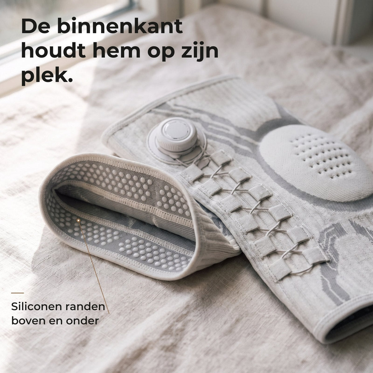 De binnenkant van de kniebrace met siliconen randen boven en onder die hem op zijn plek houden