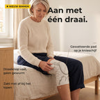 Vrouw op de rand van haar bed draait de knop van de kniebrace vast: aan met één draai