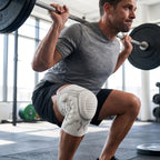 Man onderin een squat met barbell in de sportschool, kniebrace om zijn knie