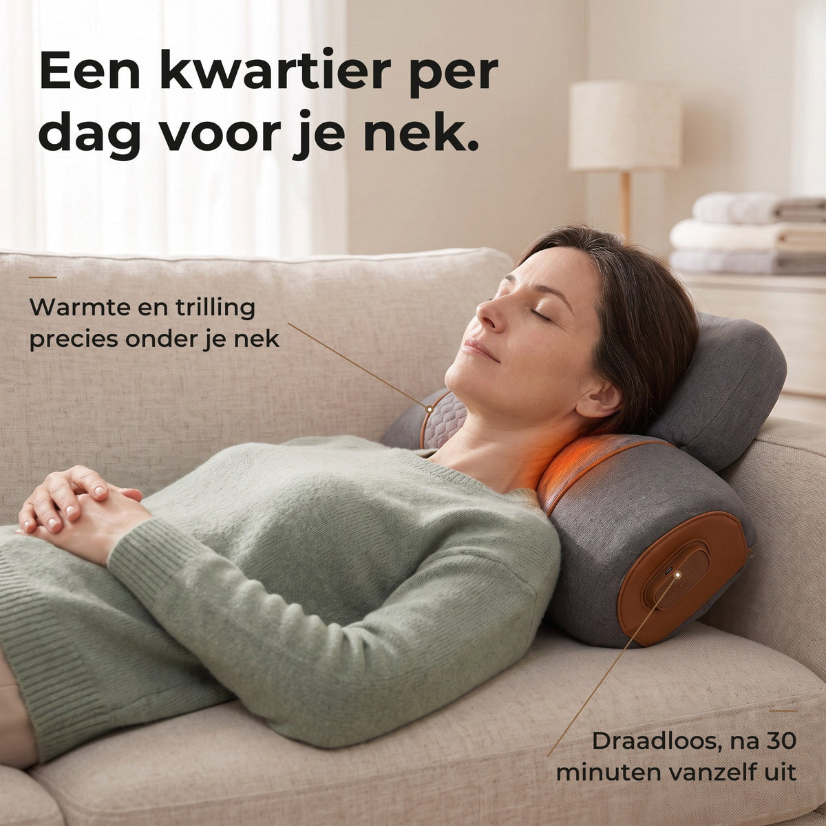Vrouw van rond de 45 ligt ontspannen op een lichte bank met haar nek op het grijze nekstretchkussen met warmte, het losse hoofdkussen onder haar achterhoofd