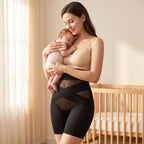 Moeder met haar slapende baby in de armen, in de zwarte shaping short in de babykamer