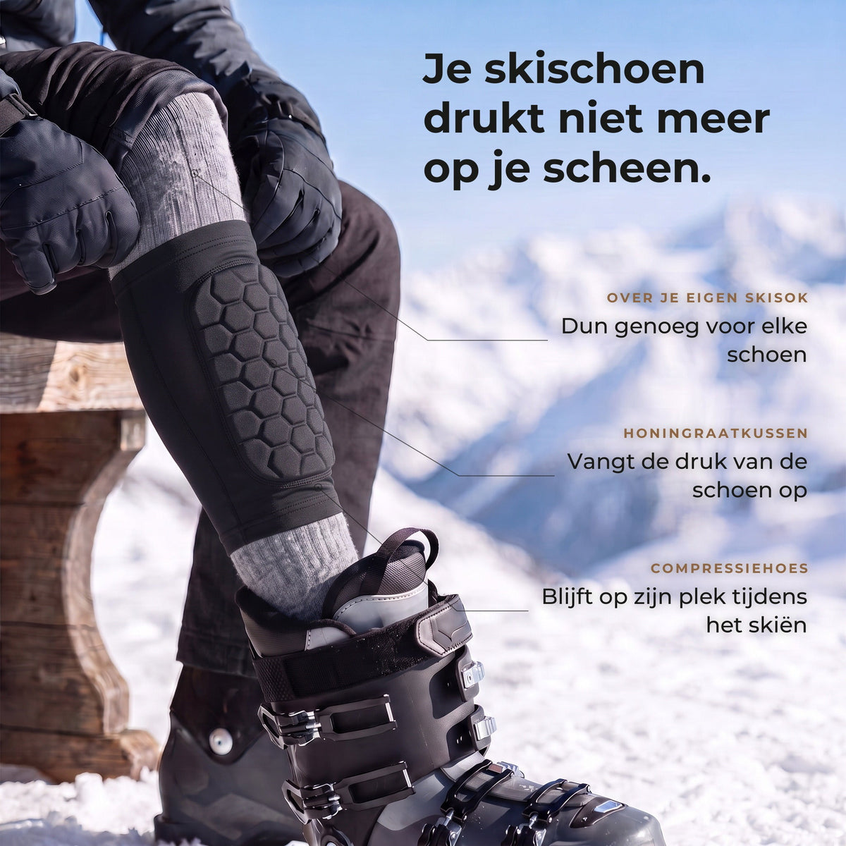 Skiër op een bank met de korte zwarte scheenbeschermer met honingraatkussen over de grijze skisok, voet in de skischoen, met drie uitleglabels
