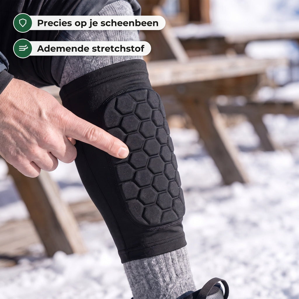 Vinger wijst naar het honingraatkussen van zeshoekjes op de voorkant van het scheenbeen