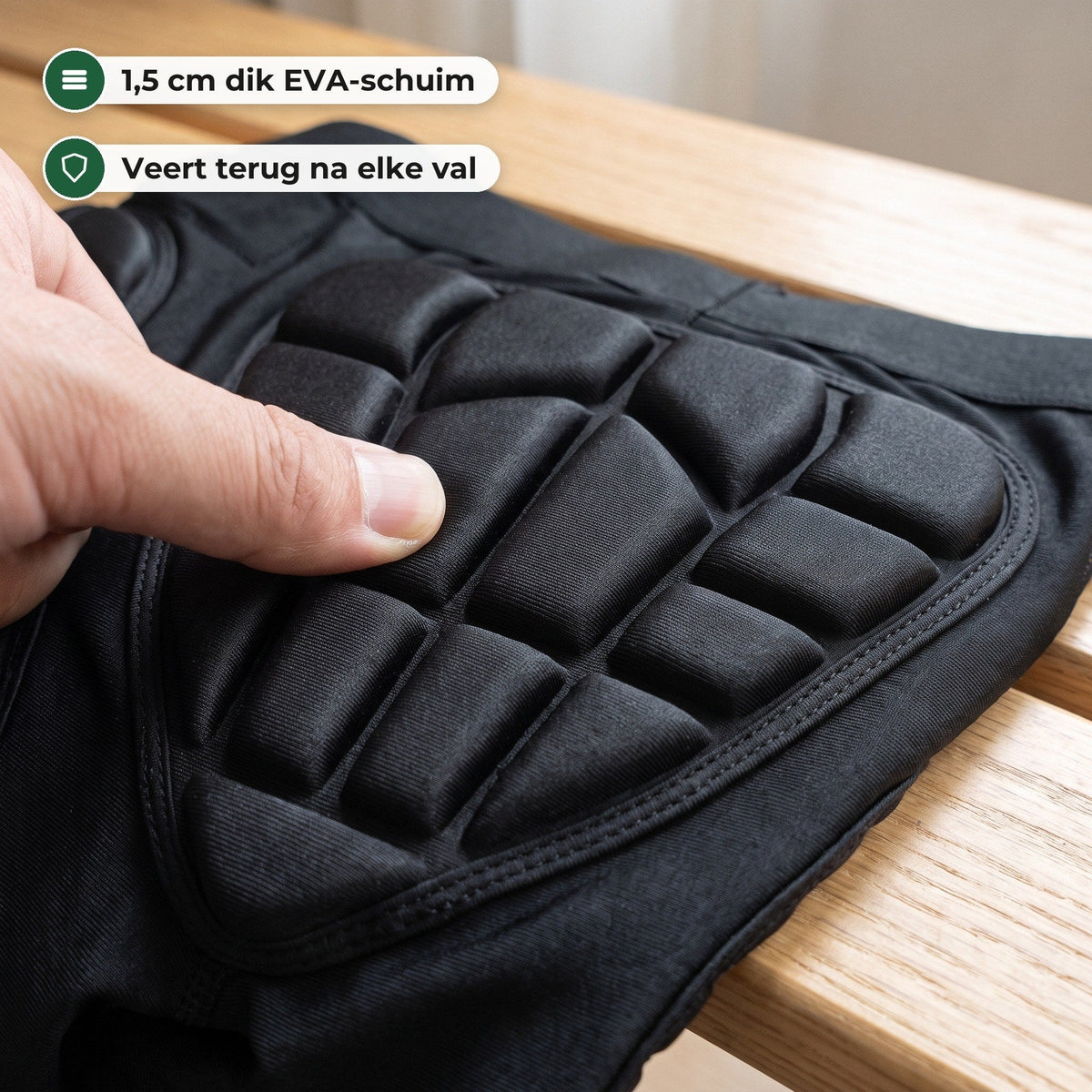 Duim drukt in het gesegmenteerde EVA-schuim van het stuitschild, close-up op een houten bank