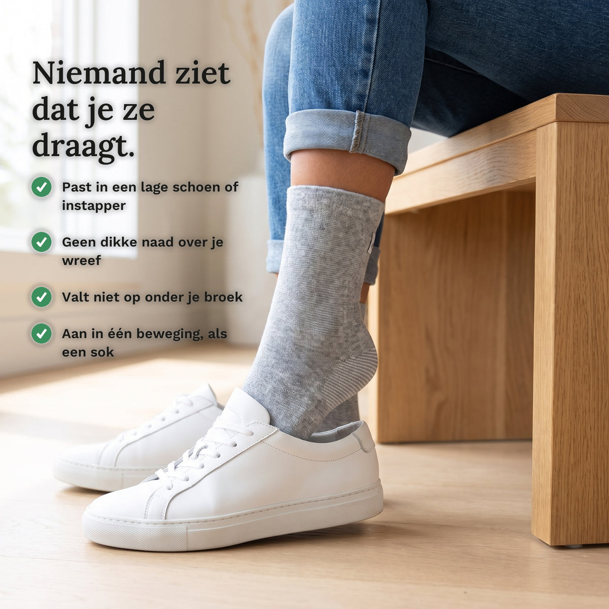 Voet met grijze voetsleeve in een witte sneaker, met vier punten over dragen onder je schoen