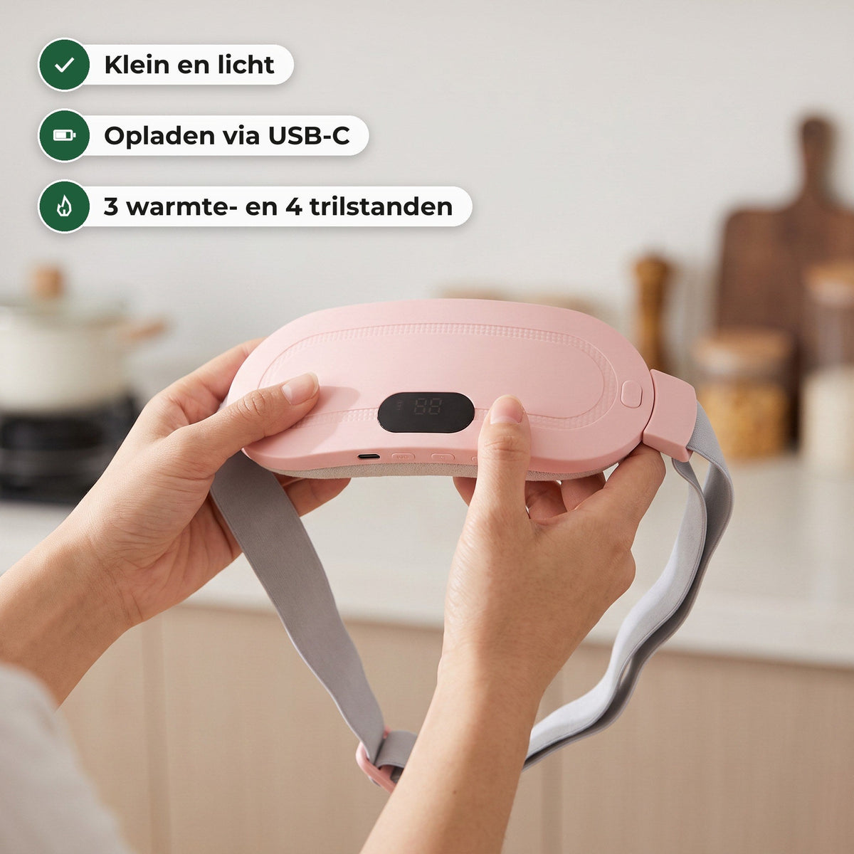 Twee handen houden de roze warmteband met het display vast in een keuken