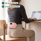 Vrouw van achteren aan haar bureau met de warmteband omgedraaid op haar onderrug