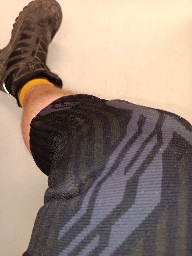 Foto van een koper: de zwarte kniebrace om de knie