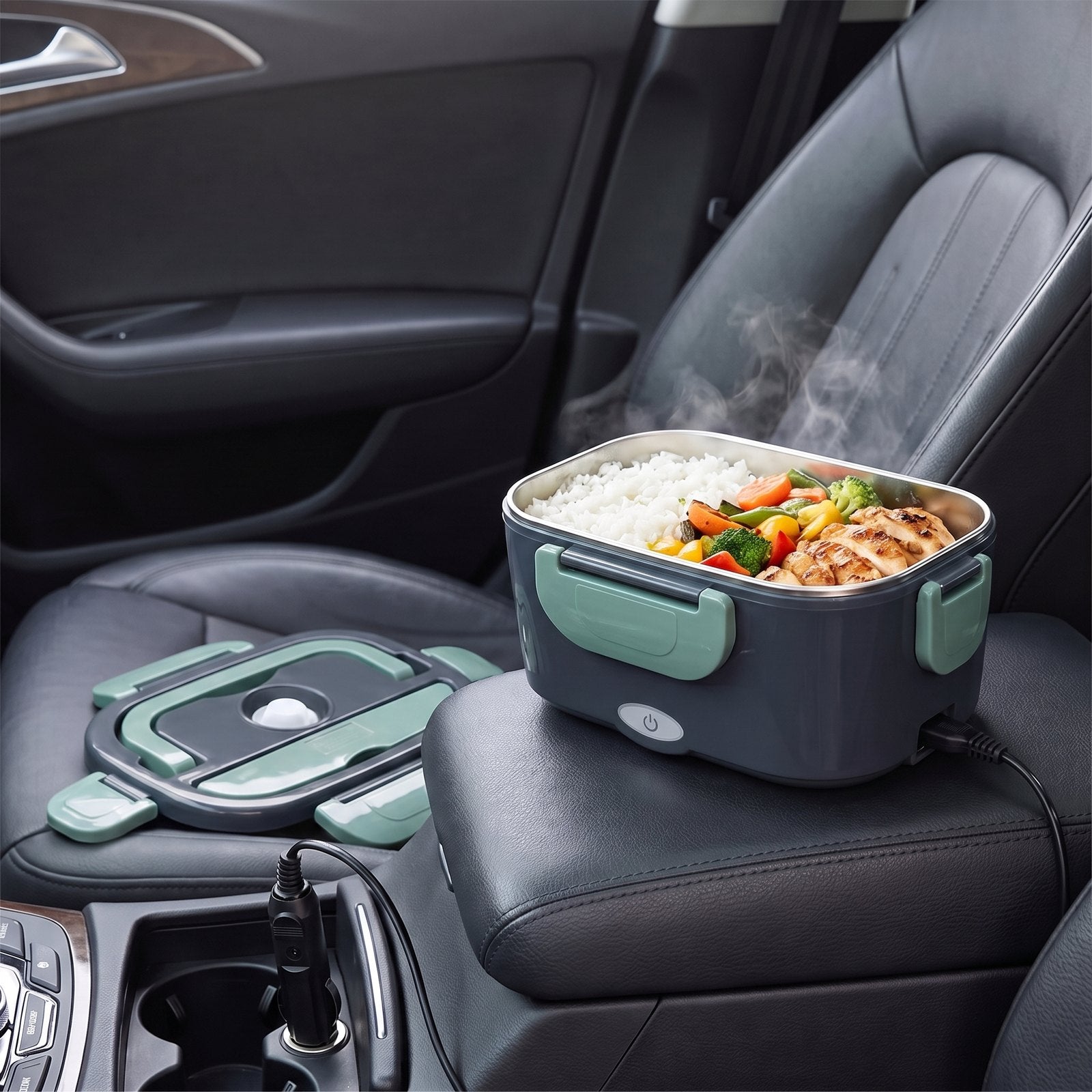 Dampende warme maaltijd in de verwarmde lunchbox op de armleuning van een auto, aangesloten op de 12V-aansluiting
