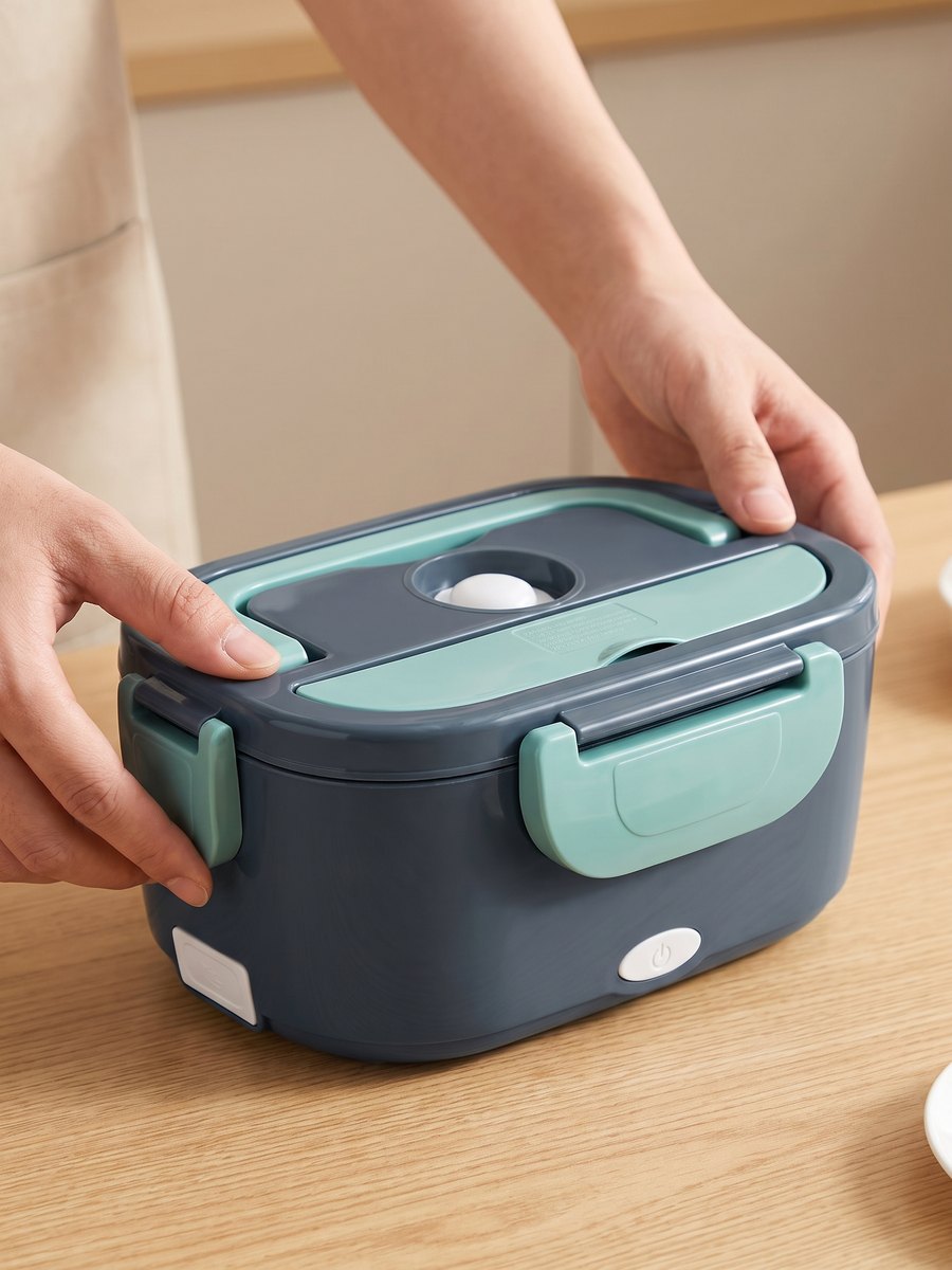 Twee handen klikken de mintgroene klem aan de voorkant van de lunchbox dicht