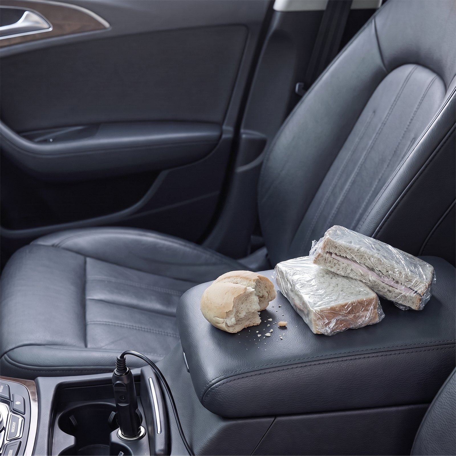 Koude boterhammen in plastic folie op de armleuning van dezelfde auto