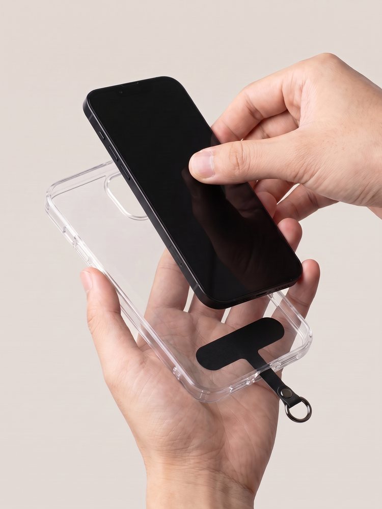 Dun plakkertje ligt in een leeg doorzichtig hoesje, het lipje met ringetje steekt onderaan uit, de telefoon gaat erin